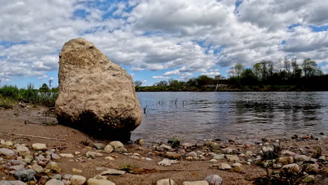 disparo de cerca del agua del lago con árboles y reflejo de nubes cayendo sobre el agua durante el día