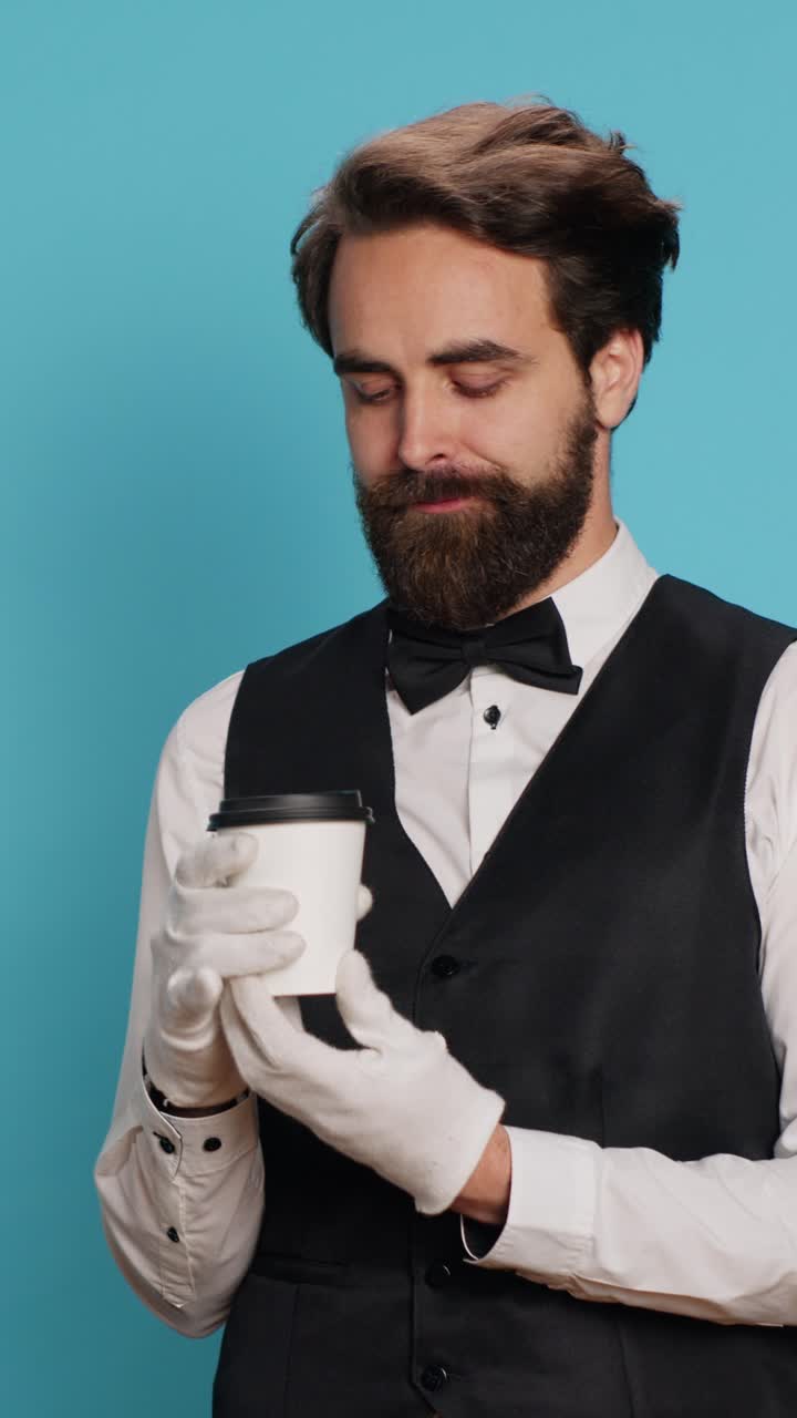 Hochformatiges Video: Hotelportier trinkt Kaffee vor der Kamera
