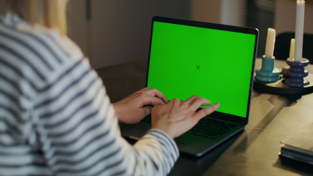 mujer trabajando en una computadora portátil con pantalla verde