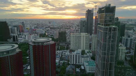 bangkok thailand's business center aerial drone fly skyscraper buildings with sunset skyline