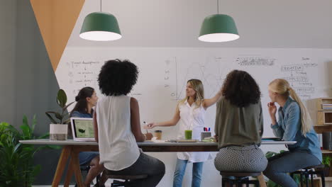 Fröhliche-Geschäftsleute-Treffen-Sich-Im-Sitzungssaal-Und-Feiern-Ein-Erfolgreiches-Projekt.-Ein-Multiethnisches-Team-Von-Frauen-Genießt-Den-Erfolg-Bei-Der-Präsentation-Am-Büroarbeitsplatz