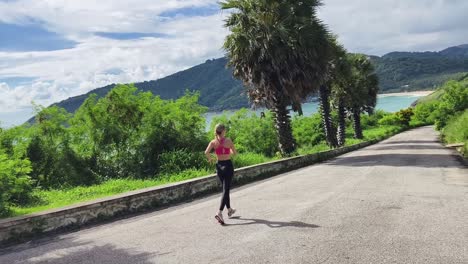 woman running along a coastal road