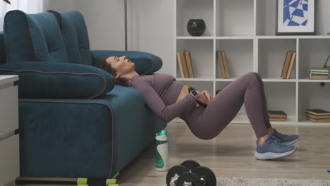 exercise for abdominal muscles young woman is lifting hips up leaning on couch holding weight on belly training at home fitness and wellness