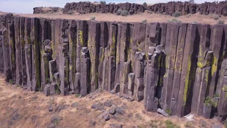 aerial rotates along lichen covered basalt column cliff in wa state