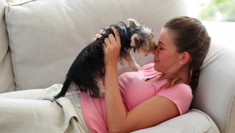 laughing woman playing with yorkshire terrier puppy