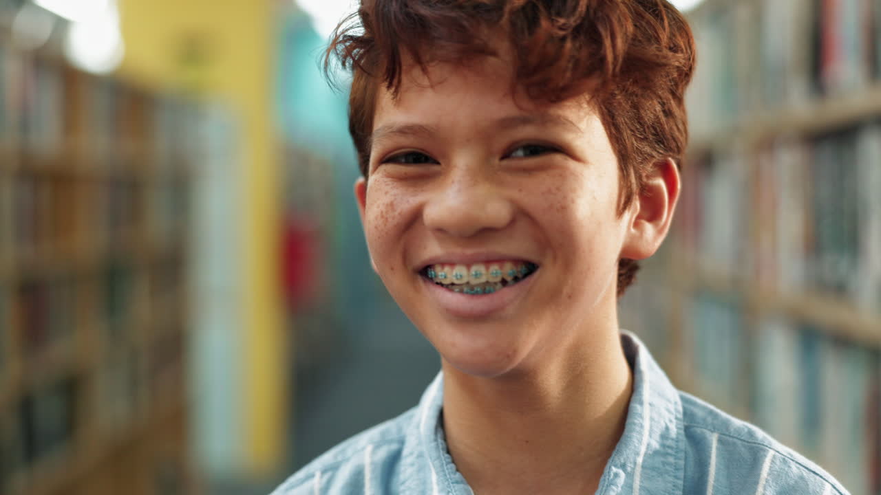 Boy with Braces Smiling in Library