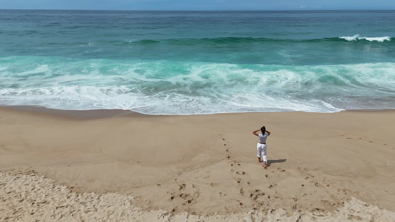 mujer caminando por una playa tropical