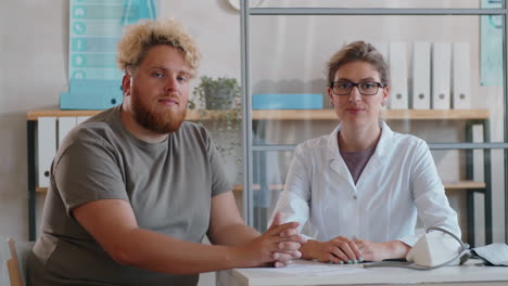 portrait of young female doctor and obese man in clinic