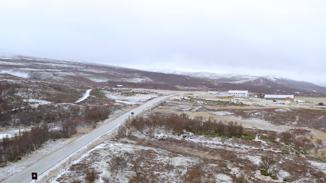 автомобиль едет по горам довре зимой в норвегии - воздушная панорама