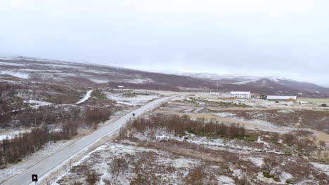 vehicle driving through dovre mountains during winter in norway - aerial panoramic