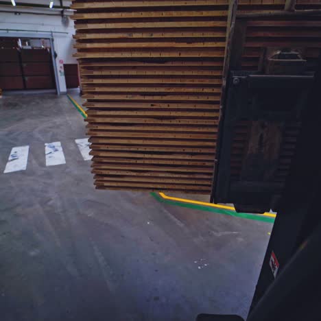 forklift is carrying wooden panels. woodworking factory indoors. huge industrial building for furniture production.