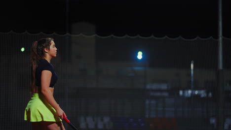 woman playing tennis at night