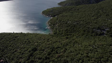 Video-with-frontal-Descriptive-Panning-Drone-advancing-over-the-coast-of-Jadranovo-and-the-island-of-San-Marcos-in-Croatia,-in-the-background-the-Krcki-bridge-and-piers-with-boats-on-the-shore