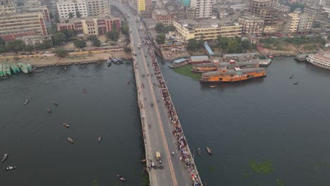 vehicles traffic and hundreds of pedestrians crossing the bridge over buriganga river in dhaka, bangladesh