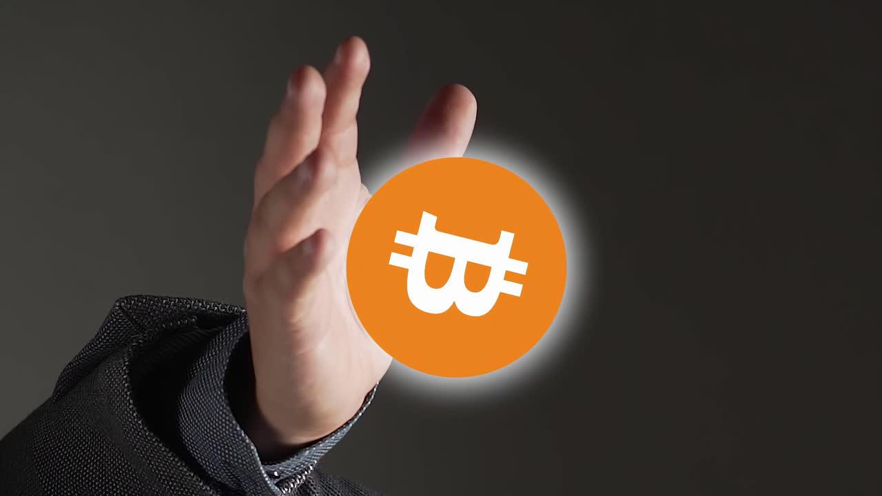 뻗은 손 위에 있는 주황색과 흰색 원형 비트코인 아이콘의 수직 비디오