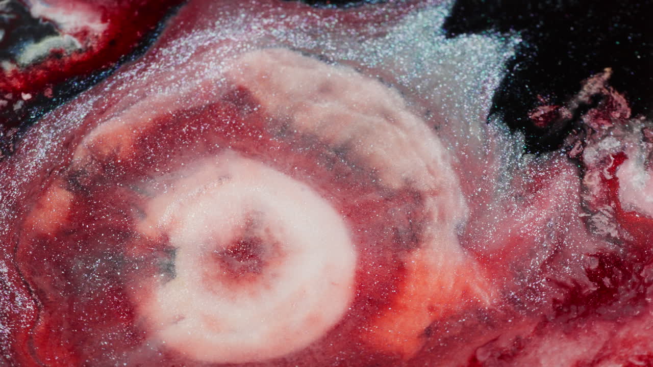 Bright ink spreading hypnotically in a dense fluid. Macro close-up