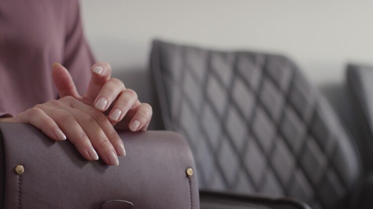 Close Up Of Nervous Female Candidate In Office Waiting For Job Interview Tapping Fingers On Bag