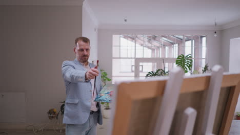 man painter examines results of art work. artist ensures each stroke and hue contributed to transformation of canvas in captivating representation