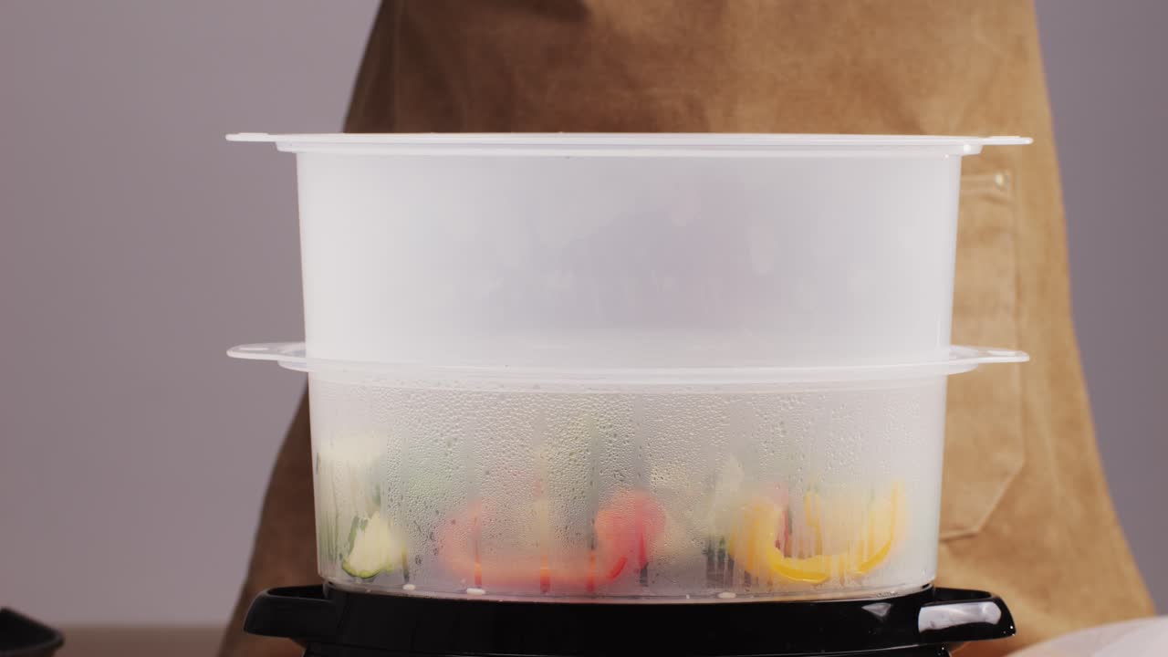 Mixed vegetables, carrots, broccoli, and cauliflower in a food double boiler steamer basket in a stainless steel pot, healthy diet cooking method preserving minerals, vitamins and flavor