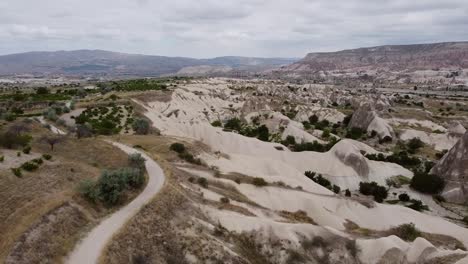 avanzando avión no tripulado aéreo sobre los paisajes de capadocia, formaciones rocosas cerca de goreme en turquía con un cielo nublado