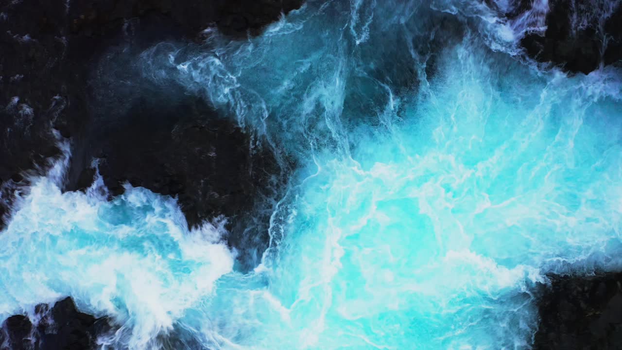 Vista aerea dall'alto della cascata Bruarfoss di colore blu che schizza durante una giornata luminosa in Islanda