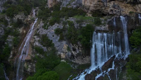 aerial-drone-view-Ujevara-E-Sotires-wild-waterfalls-in-Nivica-Canyon-with-cliffs-of-karst-gorge-with-pool