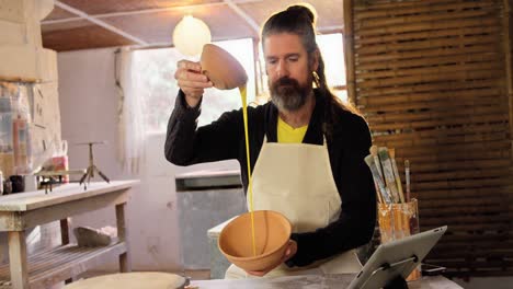 Male-potter-pouring-watercolor-in-bowl