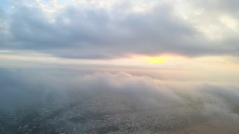 aerial drone shot capturing the serene beauty of vijayawada in the early hours, with sunlight breaking through the clouds.