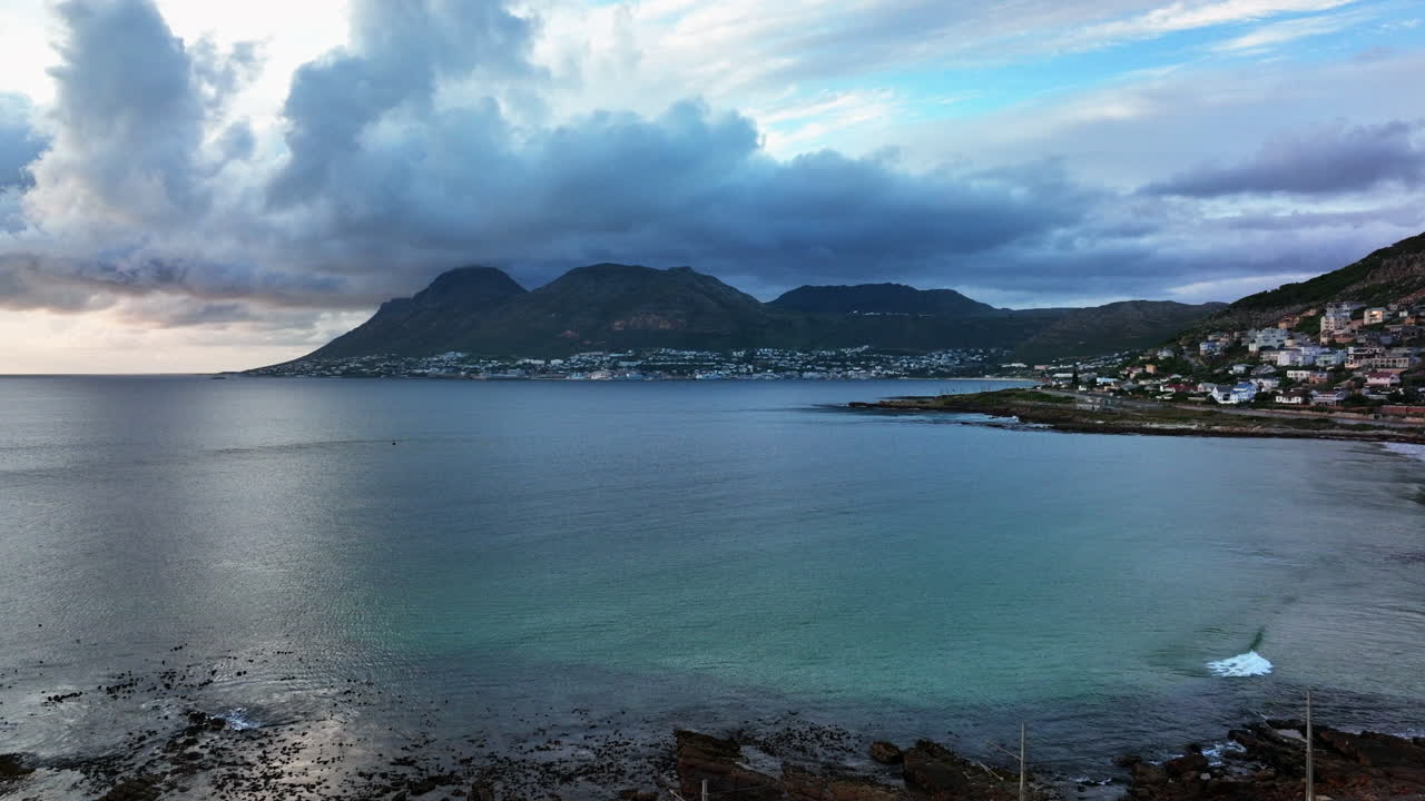 South African sunrise sunset Simon's Town drone aerial cinematic Fish Hoek rugged reef coast small fishing town marina city stunning summer spring deep aqua blue ocean train tracks forward movement