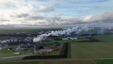 from above, the agricultural plant stands tall, its smoking chimneys contrasting