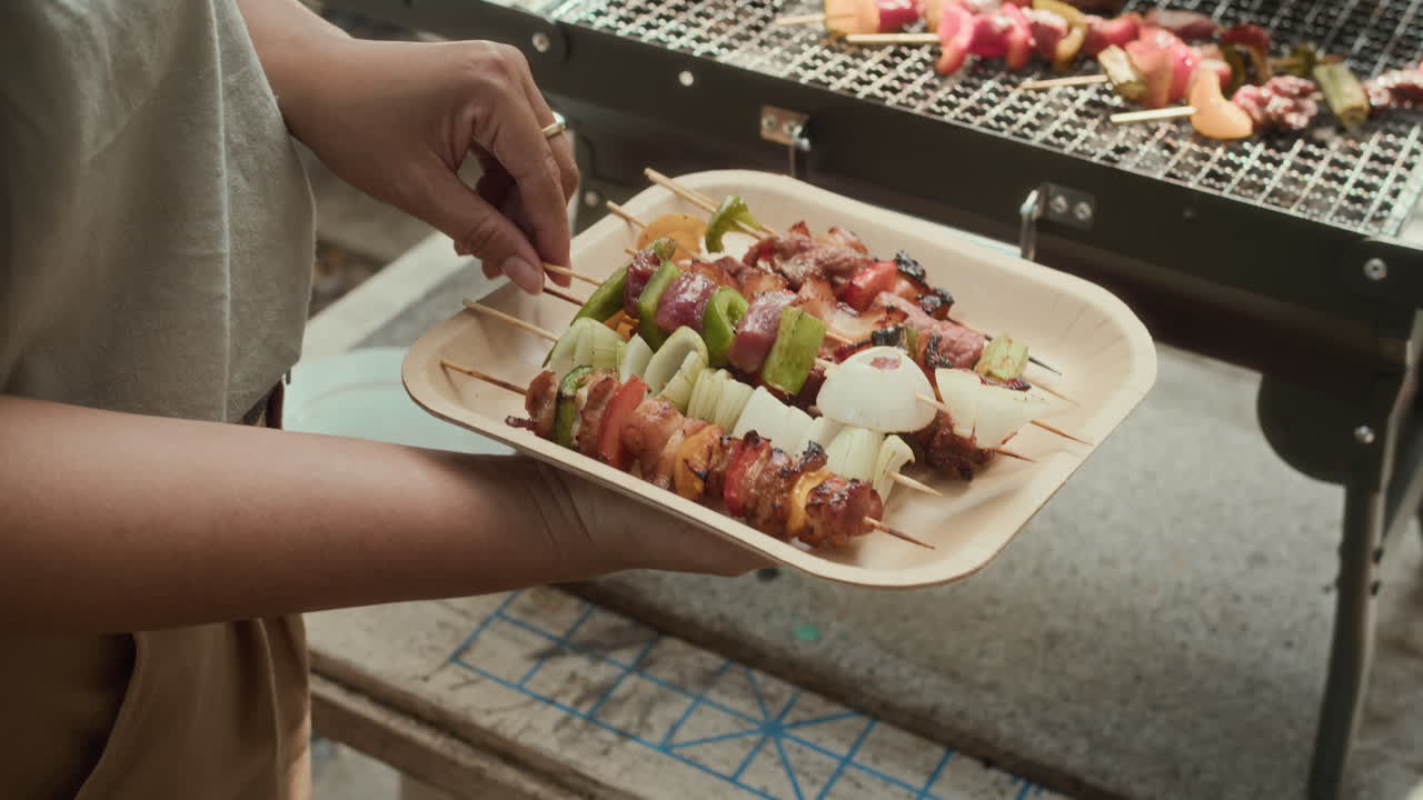 Hands of Unrecognizable Person Putting Skewers on Outdoor Grill