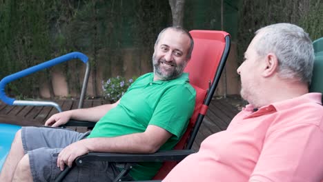 two men relaxing by the pool