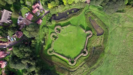 Aerial-video-footage-of-the-remains-of-Bolingbroke-Castle-a-13th-century-hexagonal-castle,-birthplace-of-the-future-King-Henry-IV,-with-adjacent-earthwork