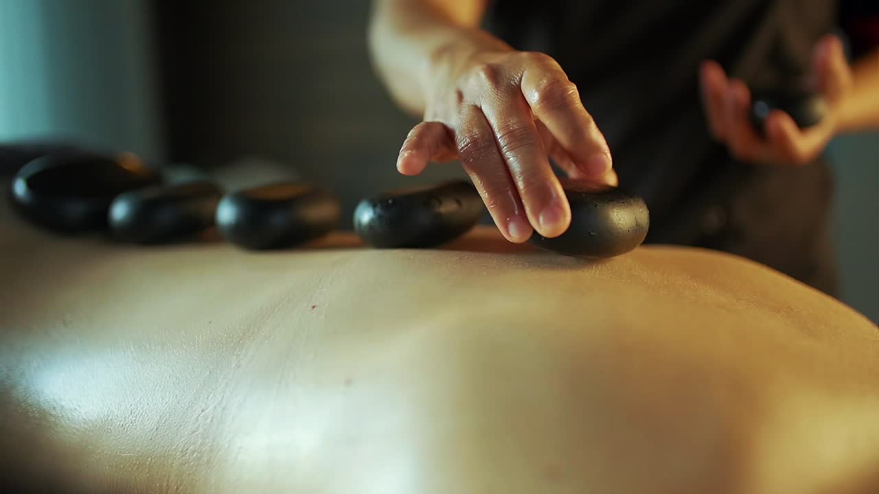 Image of a woman getting massage with stones on her back.2