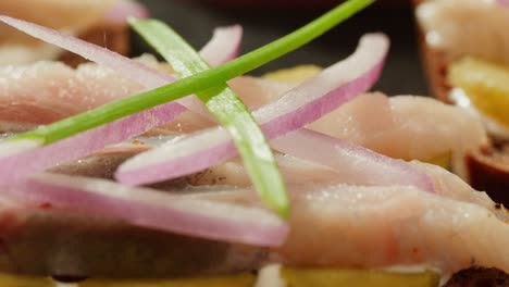 close-up of smoked herring sandwiches with onions and herbs
