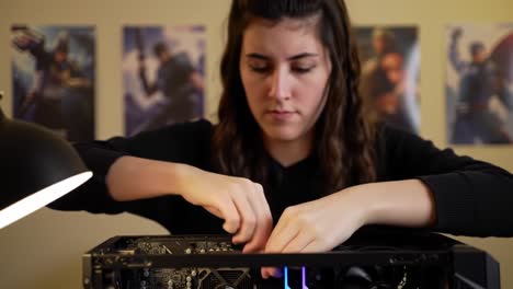 a young woman skillfully assembles a computer, focusing on the components inside the case, showcasing her expertise in technology and hardware manipulation