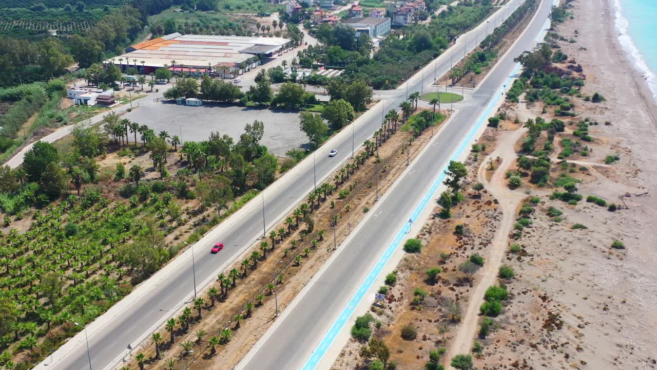 화창한 여름날 모래 해변과 야자수가 있는 피니케 칠면조의 빈 해안 고속도로 도로의 공중 전망