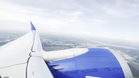 Static-closeup-shot-of-the-engine-and-wing-of-an-airplane-during-a-flight,-view-from-the-cabin