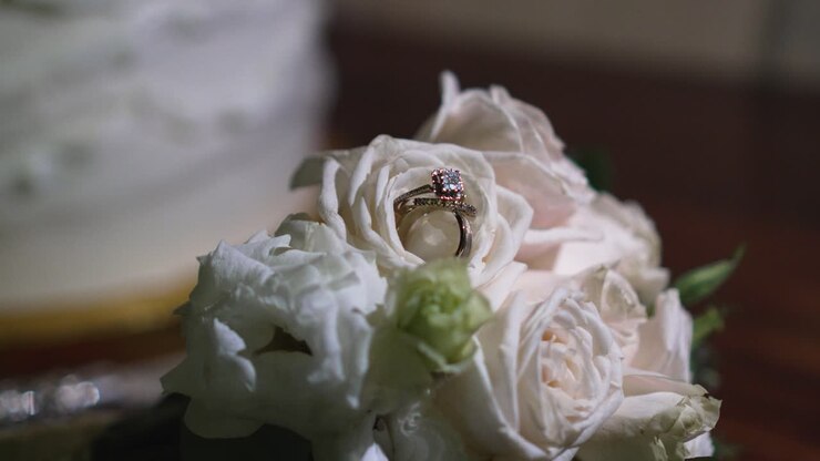 Bouquet of white roses with shiny wedding rings between their petals