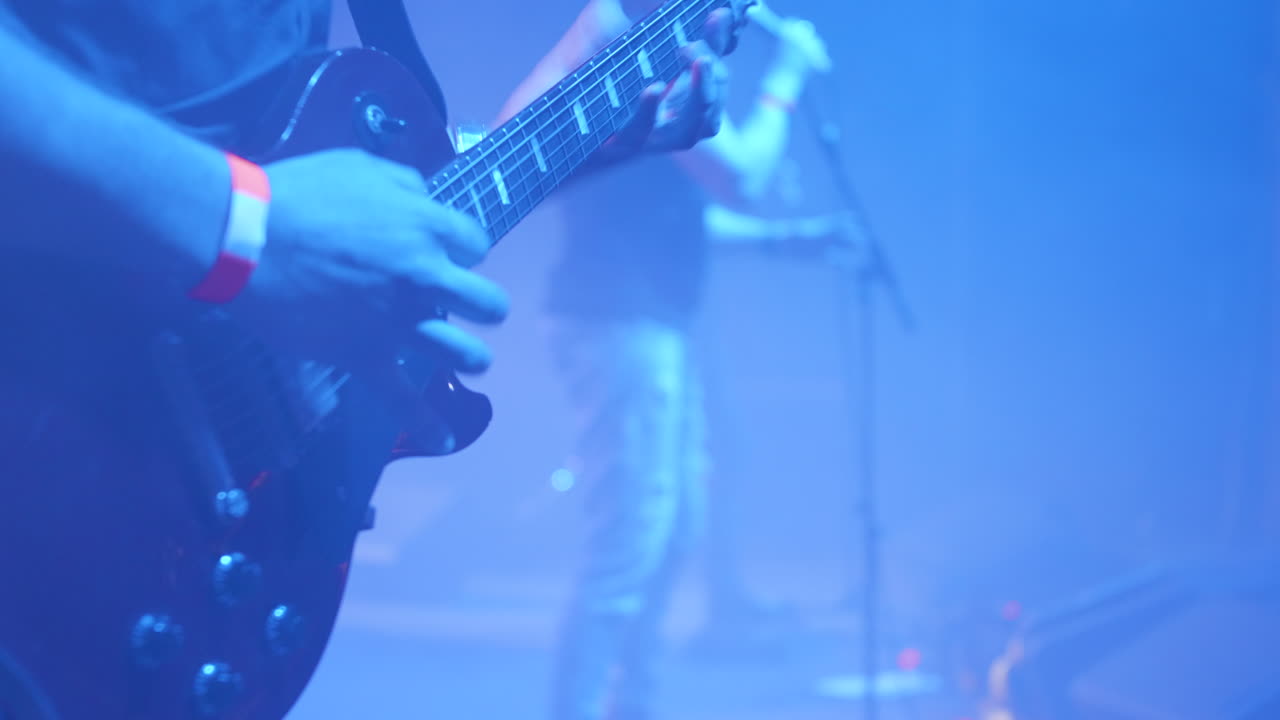 Guitarist performing on stage at a live music concert