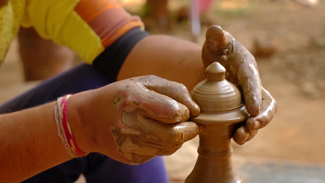 las manos hábiles del alfarero moldeando el barro en la rueda del alfarer y esculpindo jarras de barro. shilpagram, udaipur, rajasthan, india