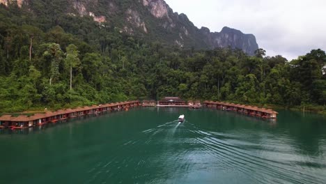 video de un avión no tripulado de 4k de un barco navegando hacia algunos bungalows flotantes en el parque nacional de khao sok