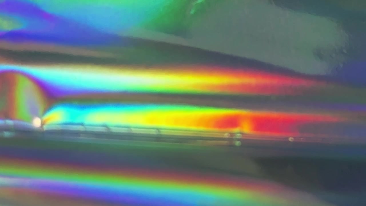 Superficie olografica astratta con riflessi di luce arcobaleno cangianti
