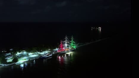 italian historical sailing ship amerigo vespucci moored at night in dominican republic with flag colors