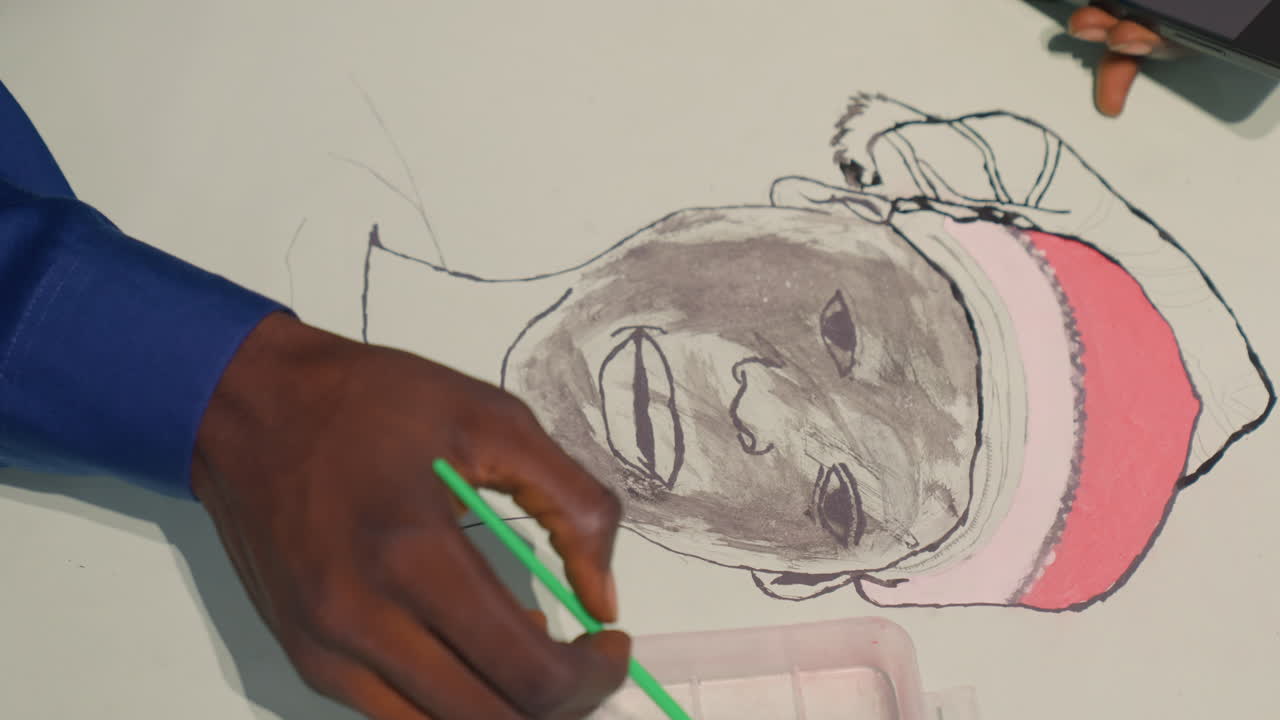 Overhead portrait painting by black artist, blue sleeve and green pen tracing facial outline, smile forming from charcoal wash, framing strokes add contrast, stepwise lesson atmosphere, careful