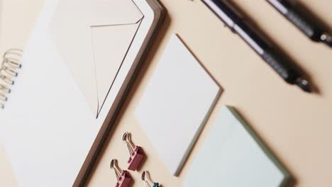 Flat-lay-of-pens,-envelope-and-memo-notes-with-copy-space-on-yellow-background