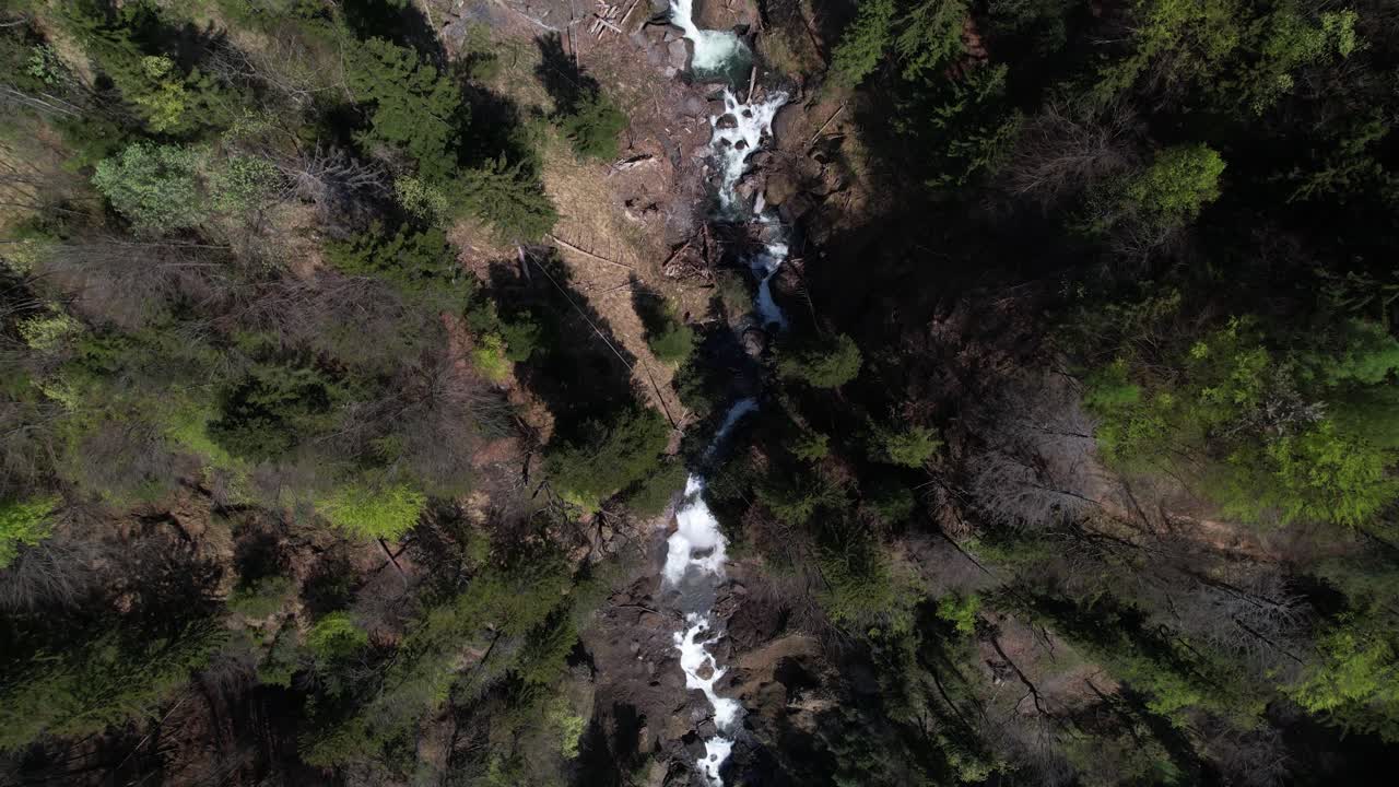 vista de arriba hacia abajo de un dron del río en un desfiladero profundo y una cascada en suiza