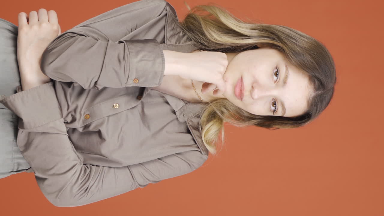 카메라를 향해 눈을  ⁇ 이는 젊은 여성의 수직 비디오.