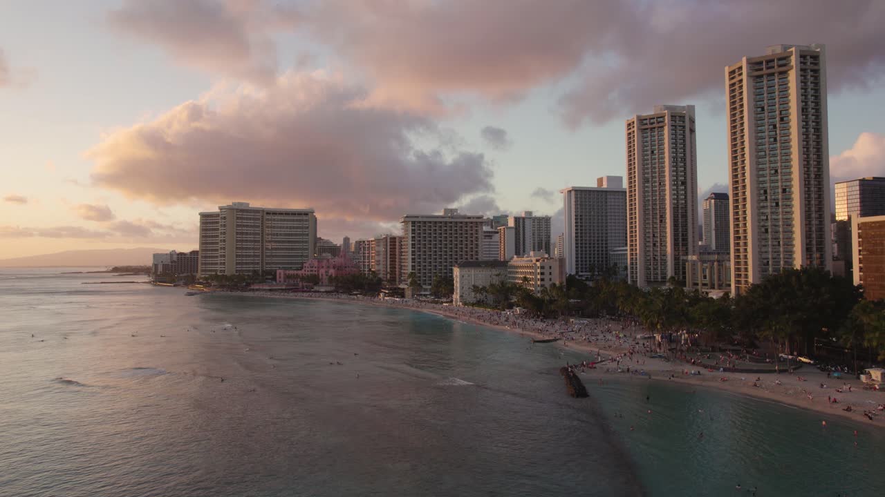 Vista aerea della spiaggia di Waikiki al tramonto alle Hawaii, persone che nuotano e fanno surf