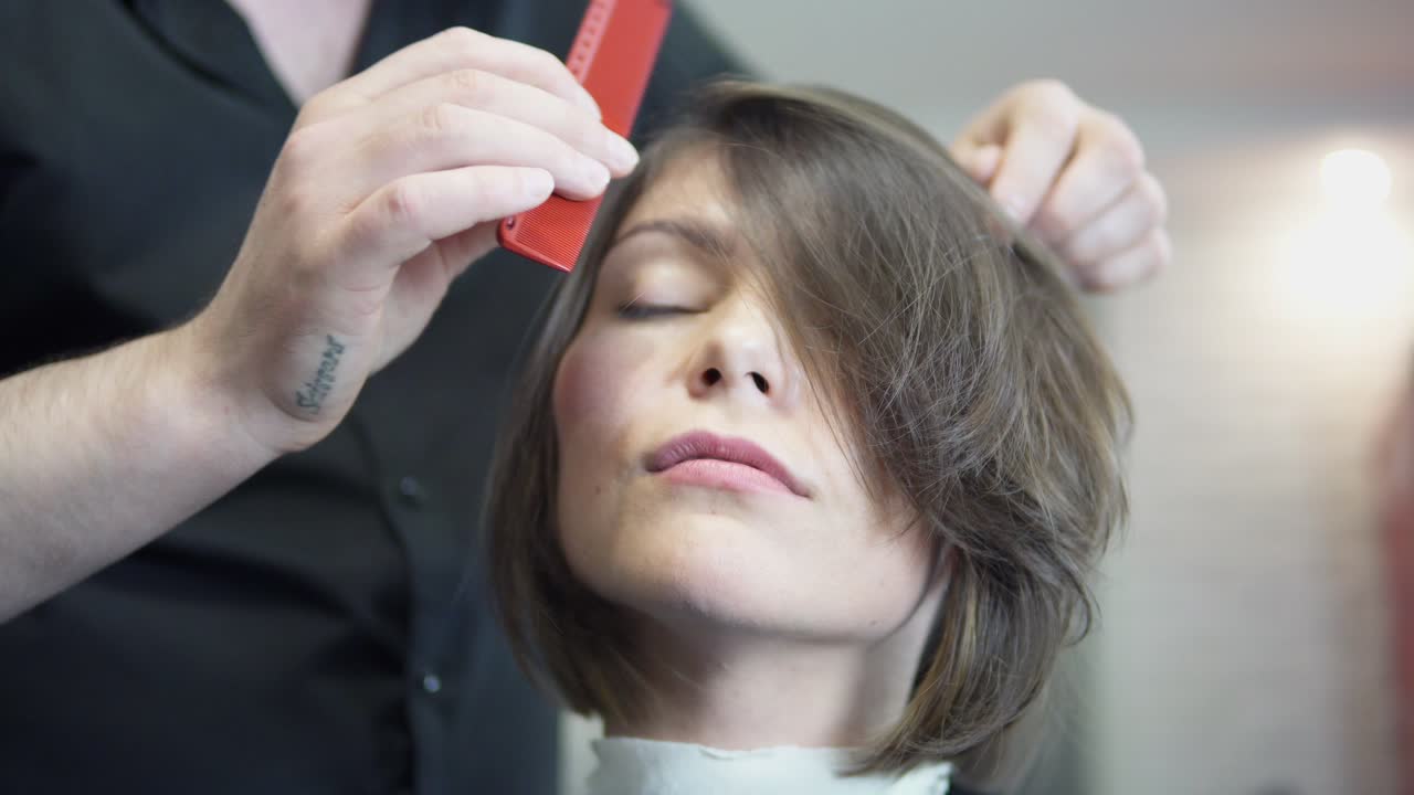 peluquero profesional, estilista peinando el cabello de la cliente femenina y usando barretas para arreglar el peinado en el salón de peluquería profesional. concepto de belleza y cuidado del cabello